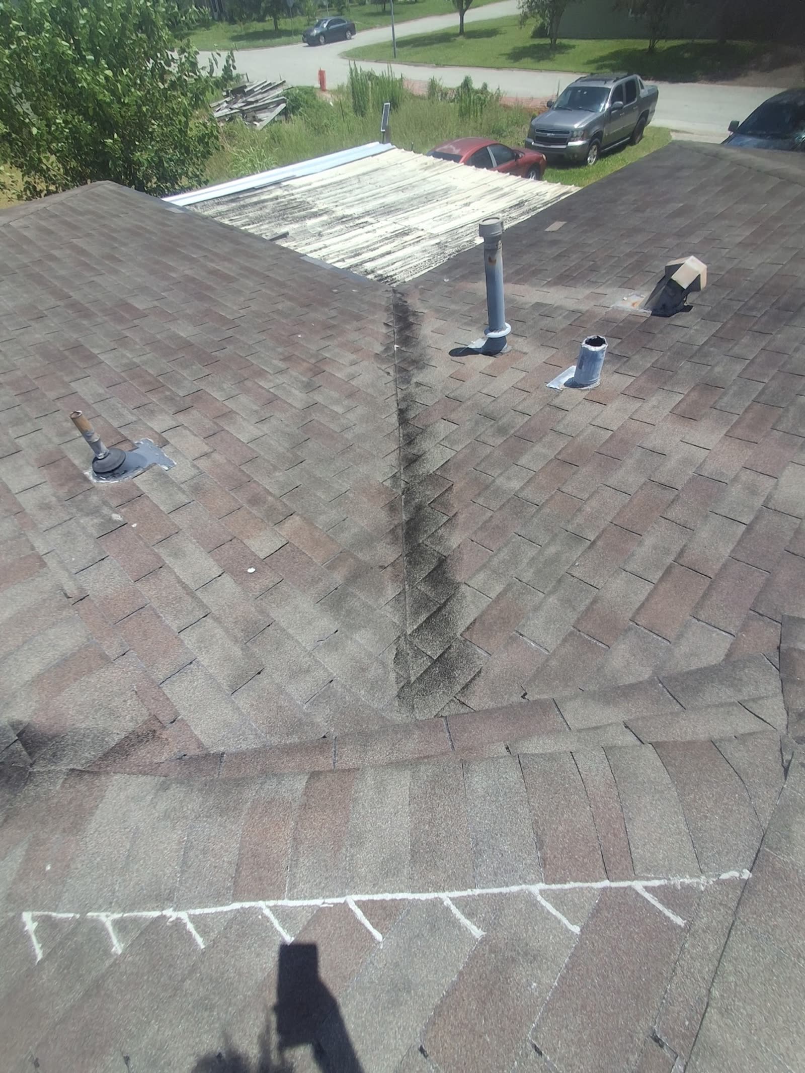 Before: Before and after: aging, chalk-marked Houston roof beside the finished replacement